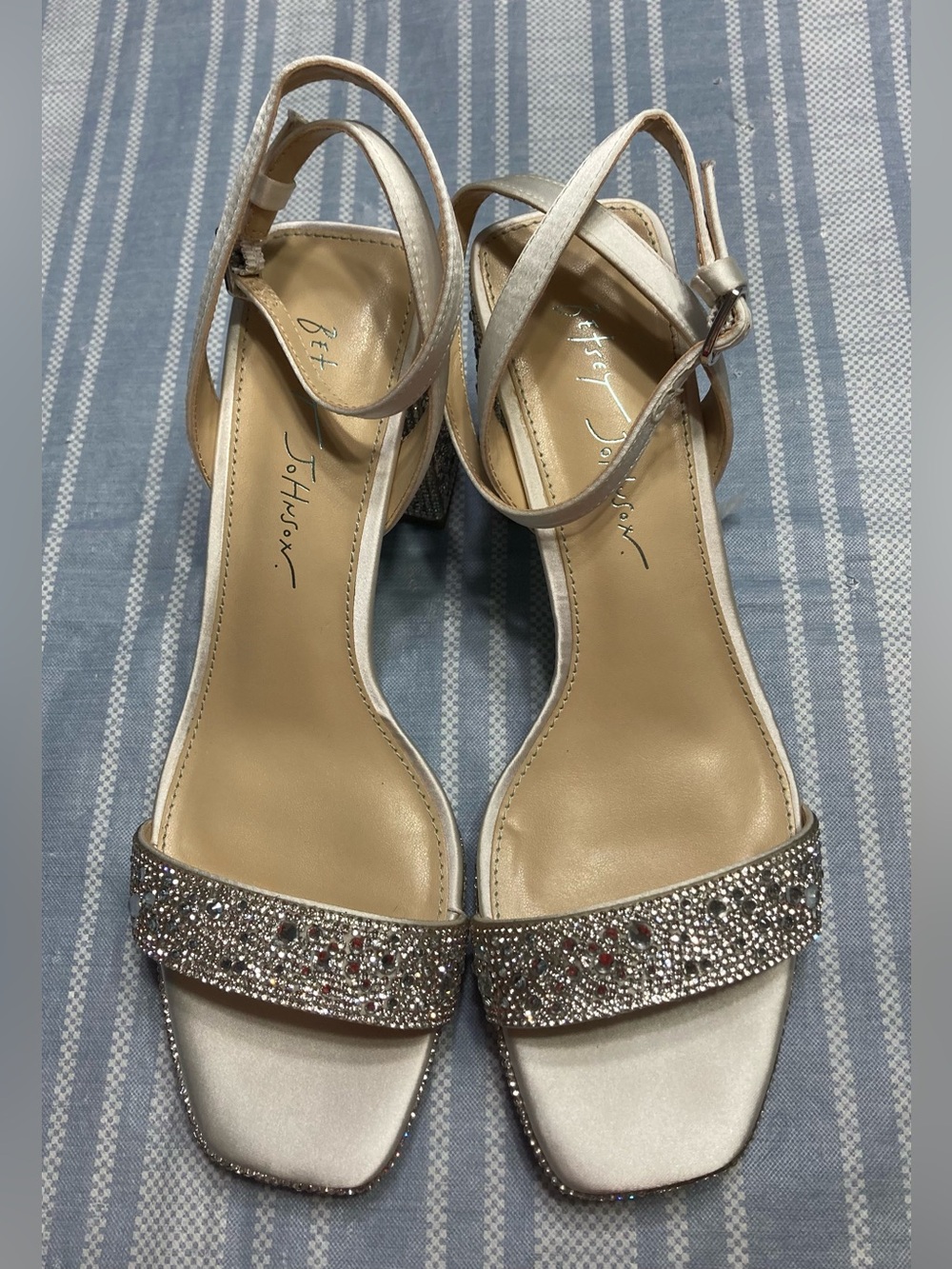 Betsey Johnson “Darbi” silver satin heels with rhinestone details.